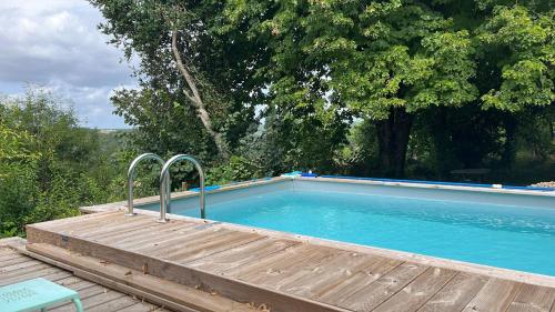 une grande piscine avec une terrasse en bois à côté dans l'établissement 1 Rue Pasquet Pool Suite with Kitchen, à Beaumont-du-Périgord