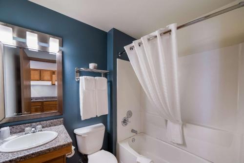 uma casa de banho com um lavatório e um chuveiro. em WoodSpring Suites Fort Worth Fossil Creek em Fort Worth