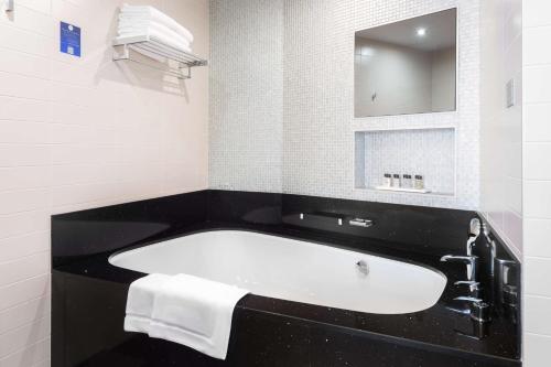 a bathroom with a bath tub and a mirror at Radisson Resort, Zavidovo in Zavidovo