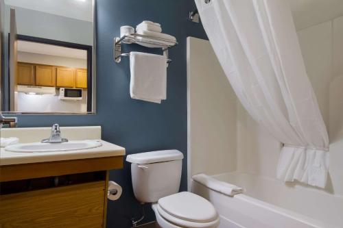 a bathroom with a white toilet and a sink at WoodSpring Suites Jacksonville I-295 East in Jacksonville