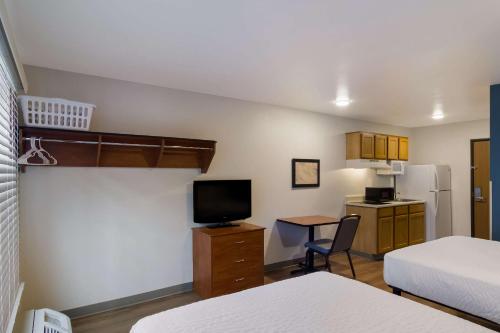 Kleines Zimmer mit einem Zimmer mit einem Bett und einer Küche in der Unterkunft WoodSpring Suites Jacksonville I-295 East in Jacksonville