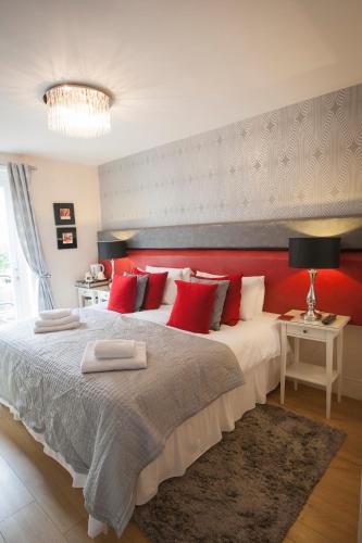 a bedroom with a large bed with red pillows at The Leicester in Southport