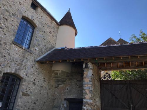 een stenen huis met een poort en een gebouw bij Le Saint Léonard in Montceaux-lès-Provins