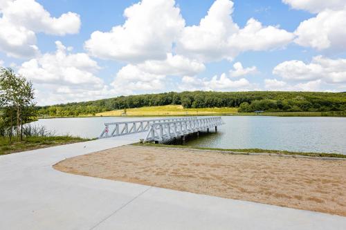 a bridge over a lake with clouds in the sky at Complex Acom in Baile Felix