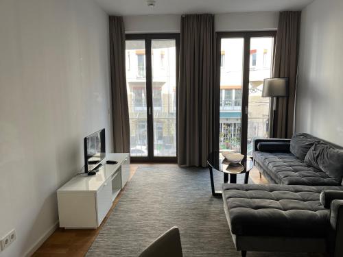 Modern Apartment in Mitte في برلين: غرفة معيشة مع أريكة وتلفزيون