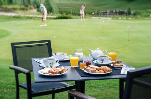 a table with breakfast food on a golf course at Domaine de Charmeil in Saint-Quentin-sur-Isère