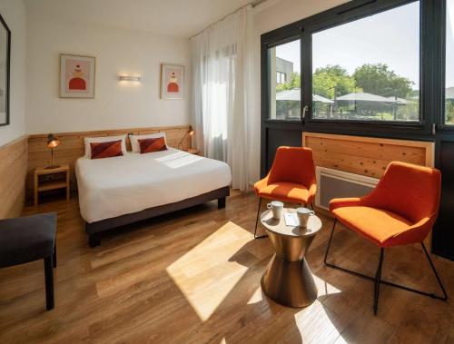 une chambre d'hôtel avec un lit et deux chaises dans l'établissement Domaine de Charmeil, à Saint-Quentin-sur-Isère
