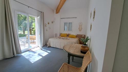 een kamer met een tafel, een bed en een raam bij Les chambres du Chateau de Fenestrelle in Aubagne