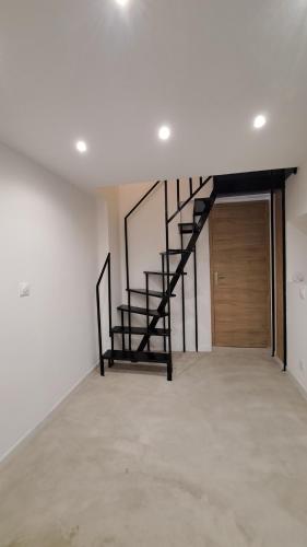 an empty room with a staircase and a wooden door at Les chambres du Chateau de Fenestrelle in Aubagne