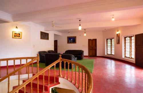 an open living room with a staircase and a couch at Misty Heights by The Sanihara in Vayittiri