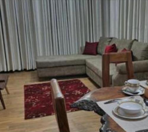 uma sala de estar com um sofá e uma mesa em Malachite apartments em Kampala