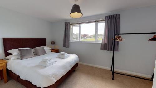 Schlafzimmer mit einem Bett mit weißer Bettwäsche und einem Fenster in der Unterkunft Taphouse Avenue in Crawley