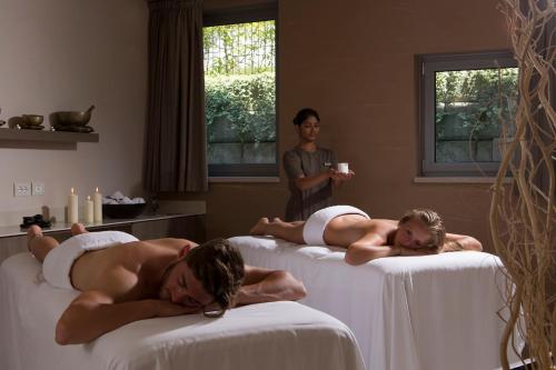 two naked men laying on beds in a room at Poiano Garda Resort Appartamenti in Garda