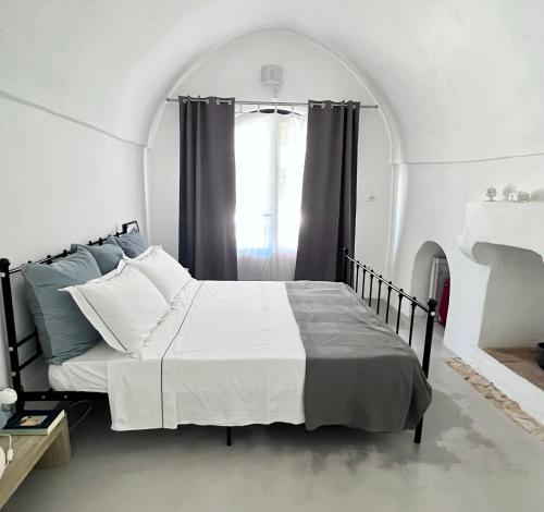 Schlafzimmer mit einem großen Bett und einem Fenster in der Unterkunft Le Lamie di Ostuni in San Michele Salentino