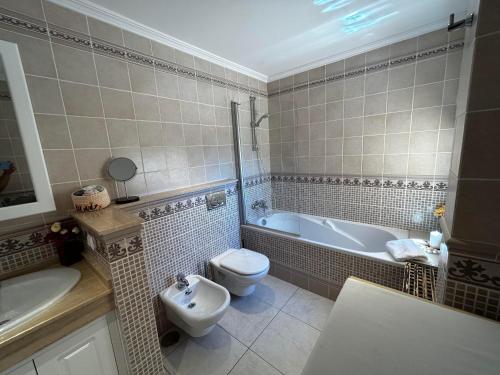 a bathroom with a toilet and a tub and a sink at Terrazas de Jandía in Morro del Jable