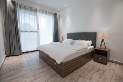 1 dormitorio con cama grande y ventana grande en Waterlily Guesthouse, en Beau Vallon