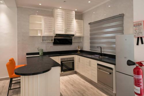 a kitchen with white cabinets and a black counter top at Waterlily Guesthouse in Beau Vallon