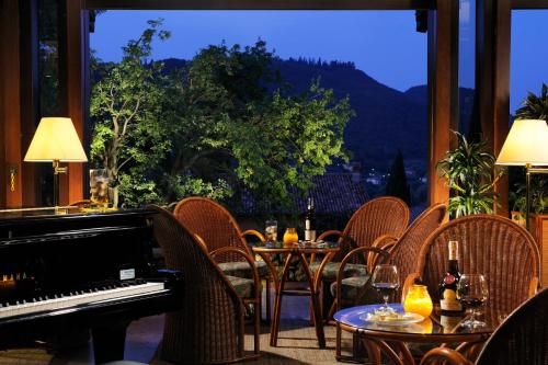 a restaurant with a piano and tables and chairs at Poiano Garda Resort Appartamenti in Garda