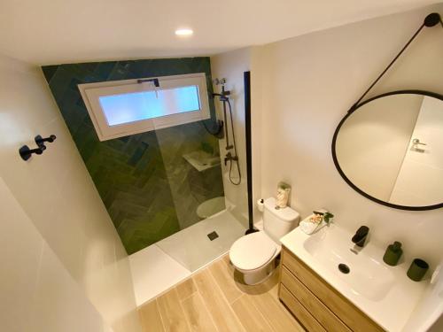 La salle de bains est pourvue de toilettes, d'un lavabo et d'un miroir. dans l'établissement La Caleta By Gloove, à La Vila Joiosa
