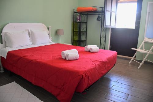 - 2 serviettes sur un lit avec une couverture rouge dans l'établissement Alojamentos Vitinho 3 for Walkers, à Vila Nova de Milfontes