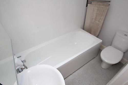 a bathroom with a toilet and a tub and a sink at Walton Lane in Oxford