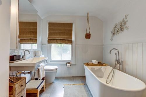 a bathroom with a tub and a sink and a toilet at The Oxford Artist's House in Oxford