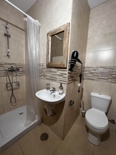 a bathroom with a toilet and a sink and a shower at Mini-hotel Casa de la Luz in Alicante