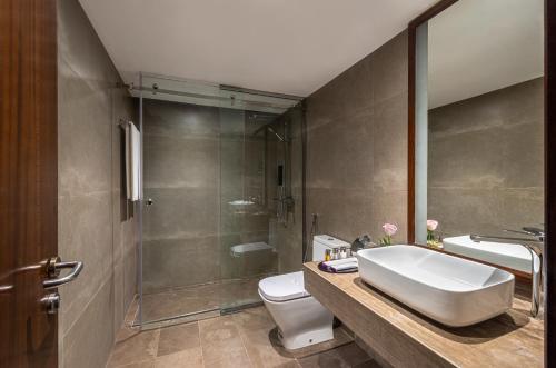 a bathroom with a sink and a toilet and a shower at Boudl Abha in Abha