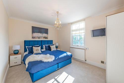 a bedroom with a blue bed and a tv at Bay Cottage in Malpas