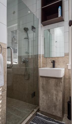 a bathroom with a shower and a sink at Castle Charm with Modern Interiors, Steps to Shops in Auckland
