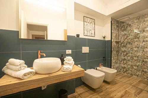 La salle de bains est pourvue d'un lavabo, de toilettes et d'un miroir. dans l'établissement Porto Antico Exclusive Apartment, à Gênes