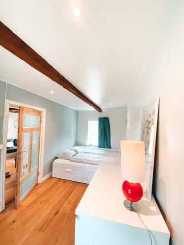 a bedroom with a bed and a red chair at Liten Päronträdgård in Perstorp