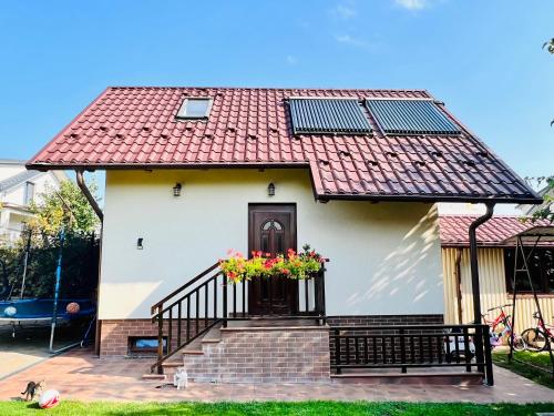 a house with a red roof with a flower box on the door at Altheda Living Tiny House in Suceava