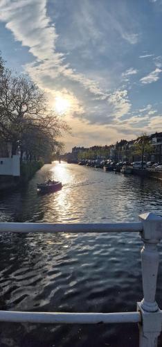 a river with a boat in it with the sun setting at City Attic Haarlem in Haarlem