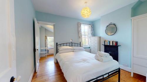 牛津的住宿－Quince Cottage，一间卧室拥有蓝色的墙壁,配有一张带两个枕头的床