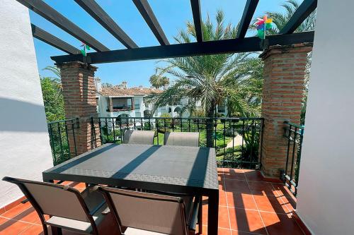 a patio with a table and chairs on a balcony at Hacienda Beach in Estepona