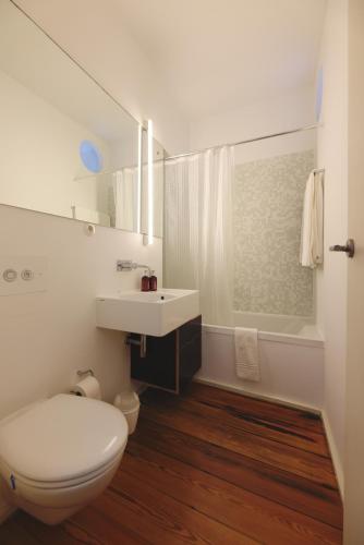 a white bathroom with a toilet and a sink at Boavista Sunlit Duplex with Terrace in Porto