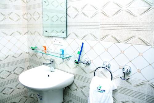 a bathroom with a sink and a toilet and a mirror at SILVERZB RESORT in Iseyin