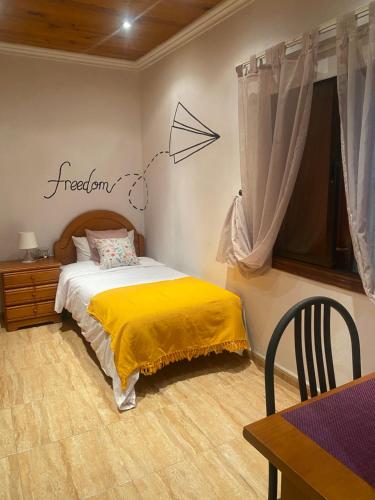 a bedroom with a bed with a yellow blanket at CASA ARIGABI in Icod de los Vinos