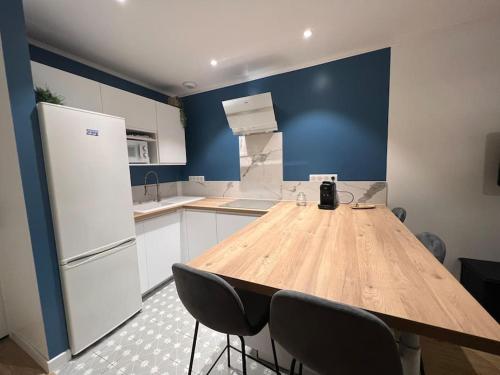eine Küche mit einem Holztisch und 2 Stühlen in der Unterkunft Appartement cosy proche du centre in Reims