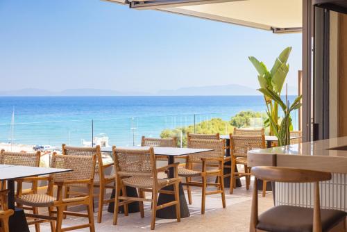a restaurant with tables and chairs and a view of the ocean at Erato by Samian Mare in Karlovasi