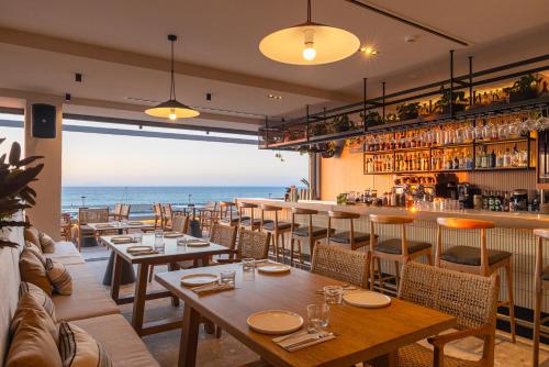 a restaurant with tables and a view of the ocean at Erato by Samian Mare in Karlovasi