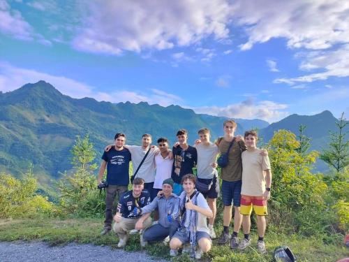 a group of people posing for a picture on a mountain at Ha Giang Donkey hostel in Ha Giang