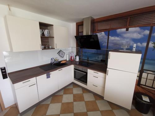 a kitchen with white cabinets and a large window at Ferienwohnung "Wißbergblick" - KEINE Monteurwohnung! in Wolfsheim