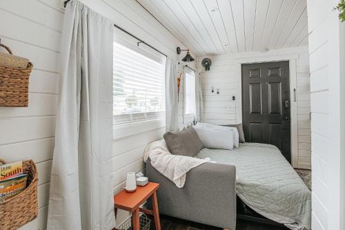 a small bedroom with a bed and a window at Downtown Tiny Home near Shenandoah National Park in New Market