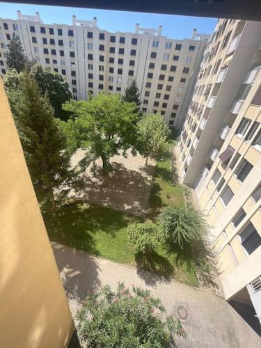 een uitzicht over de tuin tussen twee gebouwen bij Appartement in Valence