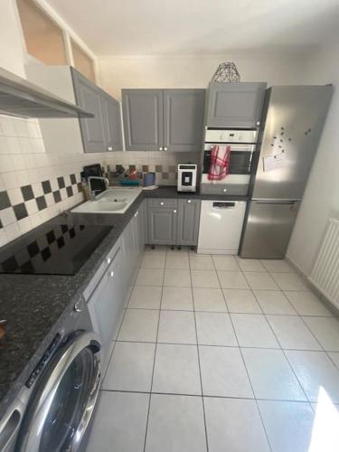 een keuken met een koelkast, een wasmachine en een droger bij Appartement in Valence