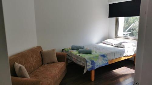 a bedroom with a bed and a couch and a window at Rix Hostel in Kyrenia
