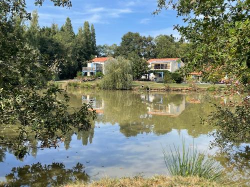 a view of a lake with houses in the background at Gîte Douceur de vivre in Saint-Avaugourd-des-Landes