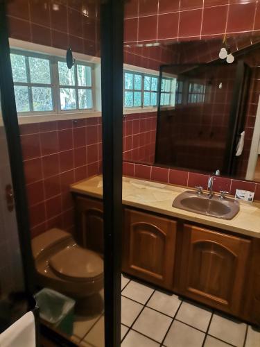 a bathroom with a toilet and a sink at La Granja de Papá Alberto in Puembo